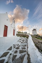 White Cycladic Greek Orthodox Twin Churches of Agios Antonios and Agios Nikolaos with Bonis Windmill at Sunrise