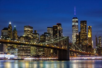 New York City skyline of Manhattan with Brooklyn Bridge and World Trade Center skyscraper at night in New York