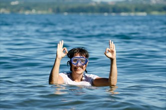 Woman with Diving Mask in the Water and Showing the OK Signal in Switzerland