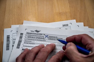 Male hand with biros in front of income tax declaration form