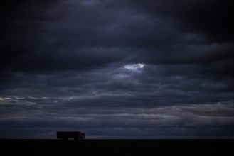 A lorry stands out on a country road at blue hour in Vierkirchen