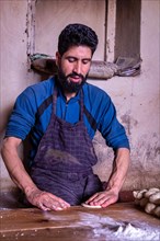 A man preparing dough for bread in Leh