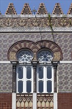Ceramic tile facade with horseshoe window