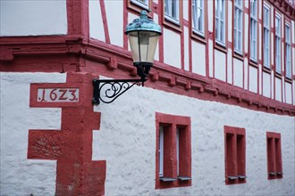 Red half-timbered house Zum Gueldenen Greif with street lamp and date 1643