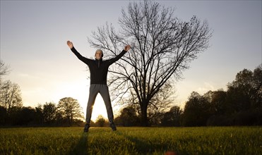 Man doing early morning exercise in autumn in a meadow.