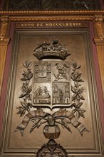 Coat of arms of the Portuens Chamber of Commerce 1889 on wood-panelled wall