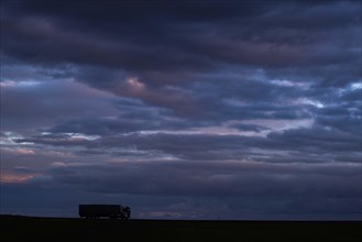 A lorry stands out on a country road at blue hour in Vierkirchen