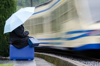 Woman sitting on her suitcase