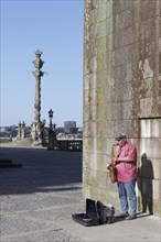 Street musician playing saxophones in front of the Se do Porto Cathedral