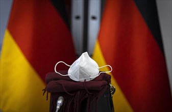 An FFP2 mask lies in front of Germany flags at the Federal Foreign Office. Berlin. 09.12.2020