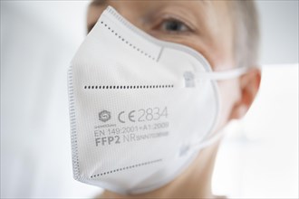 Symbol photo on the subject of FFP2 mask. A woman wears an FFP2 mask. Berlin