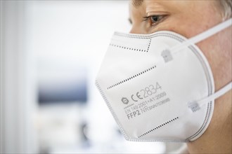 Symbol photo on the subject of FFP2 mask. A woman wears an FFP2 mask. Berlin