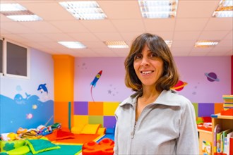 Portrait of a female kindergarten teacher inside a kindergarten