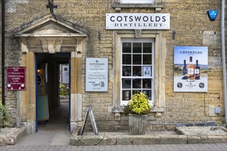 Old stone house in detail with sales shop of the Cotswolds Distillery in the old town of Bourton on the Water