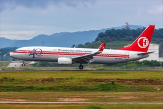 A Malaysia Airlines Boeing 737-800 aircraft with registration number 9M-MXA in retro livery at Kuala Lumpur Airport