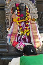 A woman bows to a goddess at the temple festival