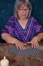 Old woman fortune teller dealing tarot cards