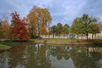 Pond in the forest during autumn colouring and former spa building