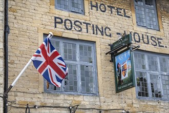 English flag and inn sign on the facade of the Hotel Posting-House in the old town of Stow-on-the-Wold
