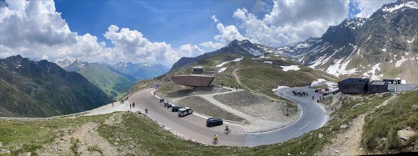 Panoramic view of pass road Alpine pass mountain road pass height of 2509 metres high Timmelsjoch Passo Rombo with pass museum rises from right Austrian territory to left in air of Italian territory