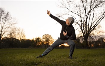Man doing chi gong outdoors in the evening light