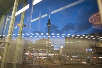 The TV tower at Alexanderplatz is reflected in a disc at blue hour. Berlin