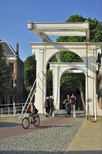 Cyclists crossing drawbridge at the Noordhavenpoort in the old harbour at Zierikzee