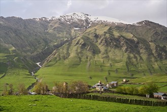 Mountain village with fortified towers against a mountain backdrop in the High Caucasus
