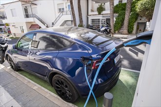Tesla electric vehicle charging at a charging station in the village of Altea La Vella