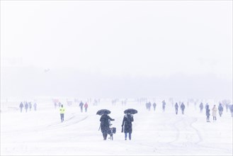 Berliners walk across Tempelhofer Feld in Berlin during snowfall