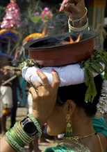 A Hindu woman carries a fire bowl during the big procession Theer