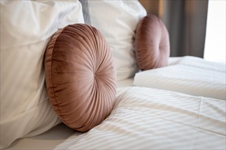 Two round pink cushions on a double bed