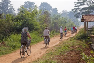 Western tourists cycling on bicycles near the Inle lake in the Nyaungshwe Township of Taunggyi District