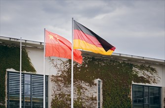 The Chinese and German national flags wave in the wind in front of the Federal Chancellery in Berlin. 19.06.2023.