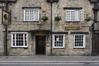 Old stone house with pub in detail in the old town of Cirencester