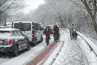 Cyclists walking on foot holding bicycles on slippery pavement