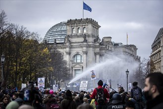 Police officers act with water cannons against demonstrators protesting against the reform of the infection protection law in Berlin