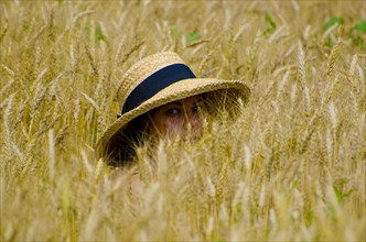 Woman in the Wheat Field with a Straw Hat