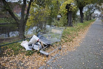 Illegal waste disposal. A shopping trolley and rubbish lie on a pavement in Berlin Moabit. Berlin