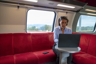 Woman Working on Laptop in First Class in a Train in Switzerland