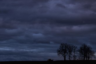 A van stands out at blue hour on a country road in Vierkirchen