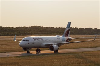 Passenger aircraft Airbus A320-214 of the airline Eurowings in the evening light on the tarmac at Hamburg Airport