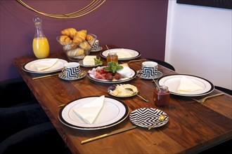 Set dining table with golden cutlery and a cheese and sausage platter