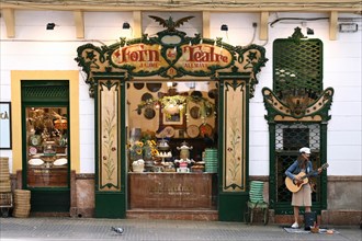 Street musician in front of the historic bakery Forn des Teatre
