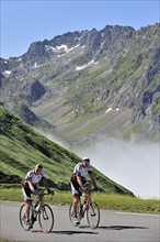 Two elderly cyclists riding towards the Col du Tourmalet in the Pyrenees
