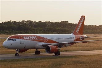 Passenger aircraft Airbus A320-214 of the airline easyJet in the evening light on the tarmac at Hamburg Airport
