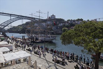 Long queue of people waiting to see the sail training vessel NRP Sagres on the banks of the Douro