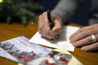 Merry Christmas. Man writes Christmas cards by hand