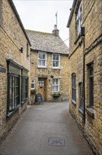 Old town lane with typical stone houses made of yellow Cotswold stone