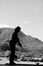 Golfer on Driving Range with Mountain in Switzerland